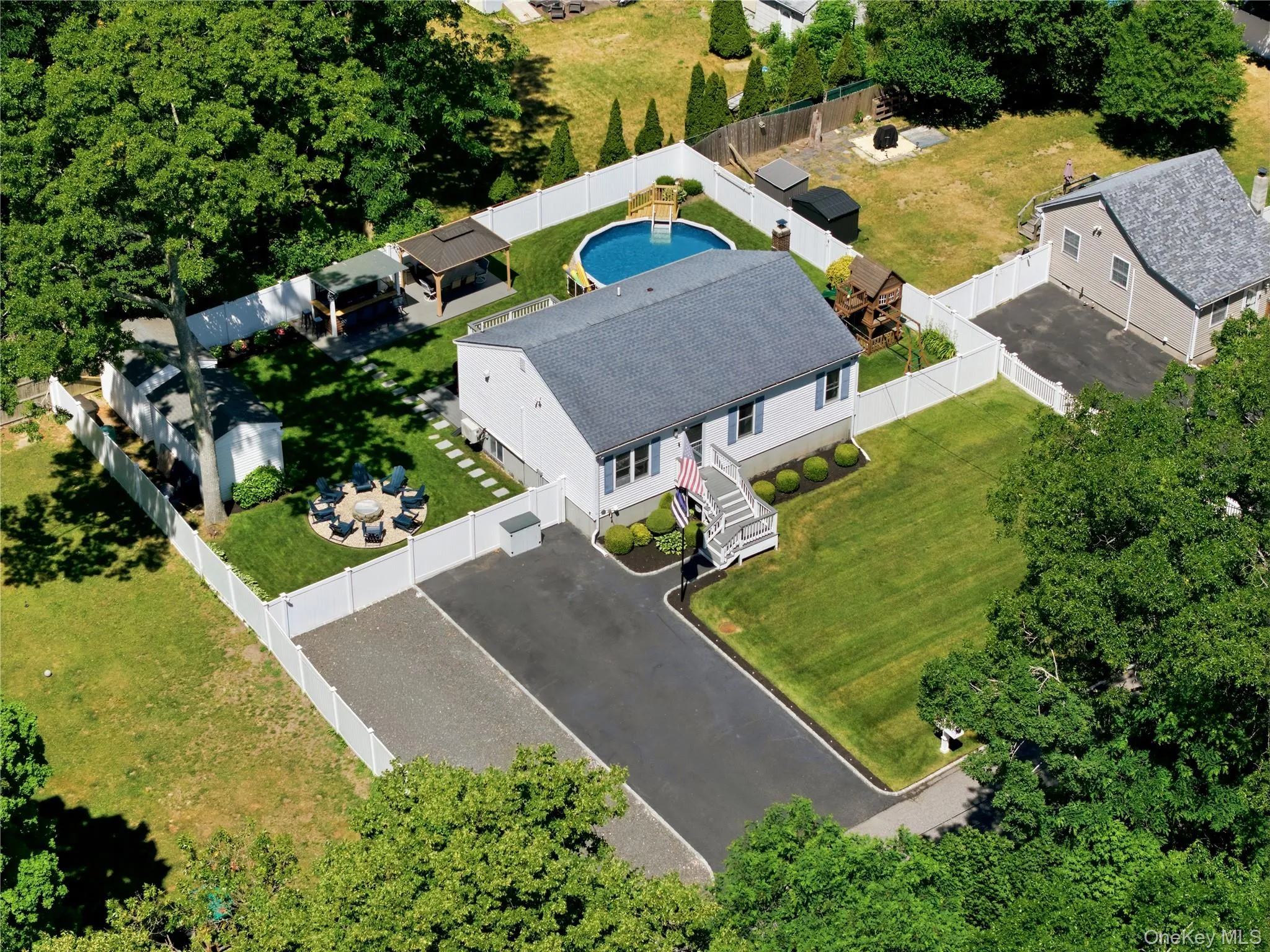 Single-story residence featuring a gray shingle roof, light-colored siding, and white trim Single-story residence featuring a gray shingle roof, light-colored siding, and white trim