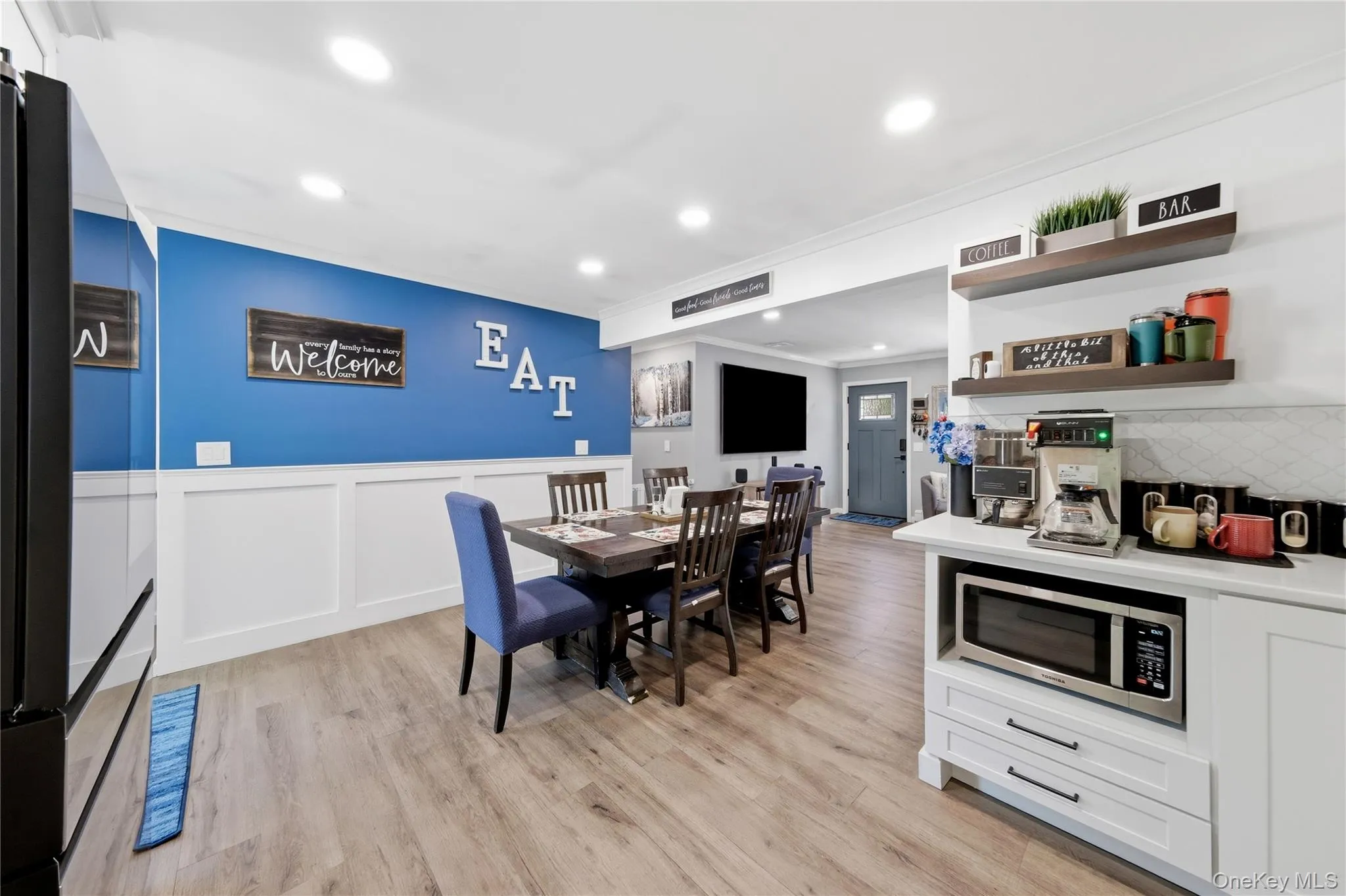 Open dining area featuring wood-finish flooring, recessed lighting, and white wainscoting Open dining area featuring wood-finish flooring, recessed lighting, and white wainscoting