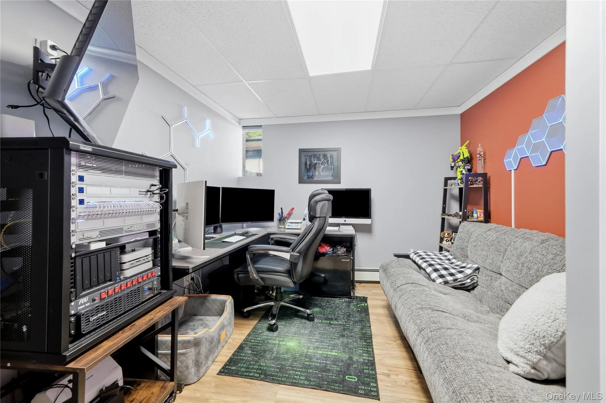 Dedicated workspace featuring wood-finish flooring, a drop ceiling with recessed lighting, and a window for natural light Dedicated workspace featuring wood-finish flooring, a drop ceiling with recessed lighting, and a window for natural light