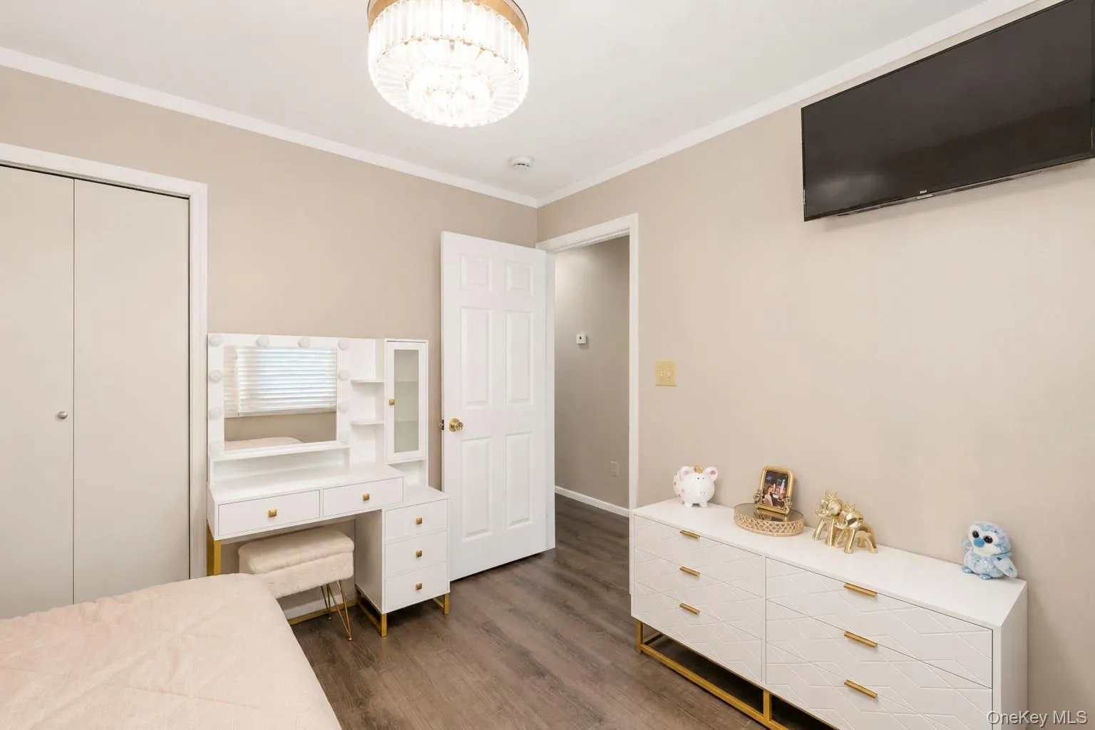 Room featuring wood-finish flooring, a contemporary ceiling light fixture, and neutral wall tones Room featuring wood-finish flooring, a contemporary ceiling light fixture, and neutral wall tones