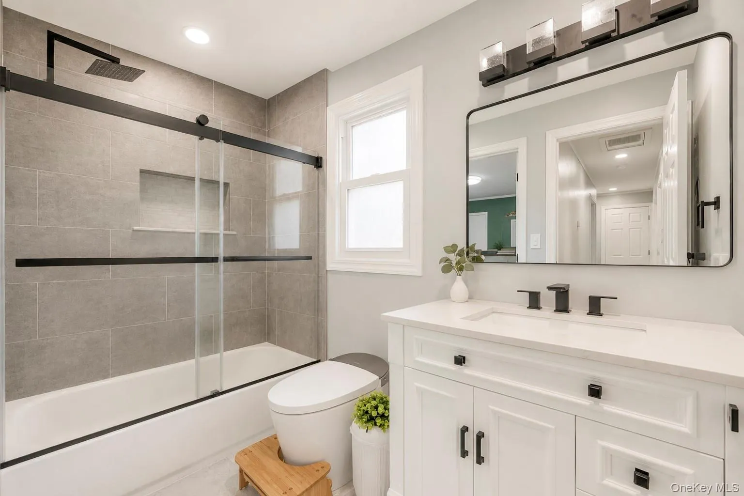 Modern bathroom featuring a white vanity with integrated sink, quartz countertop, and matte black fixtures Modern bathroom featuring a white vanity with integrated sink, quartz countertop, and matte black fixtures