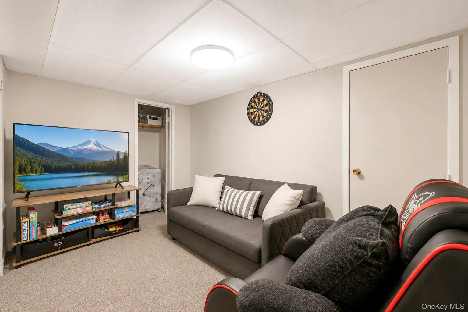 Carpeted room featuring light neutral wall paint, a drop ceiling with recessed lighting, and a solid interior door Carpeted room featuring light neutral wall paint, a drop ceiling with recessed lighting, and a solid interior door