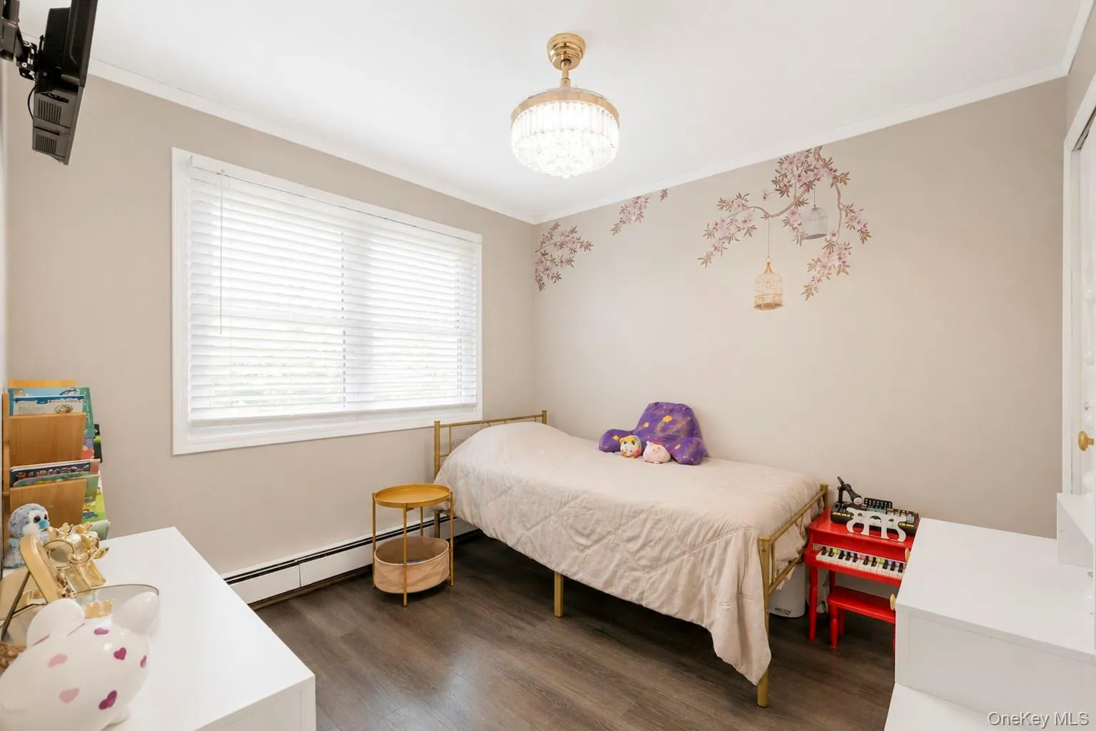Bright room with wood-finish flooring, featuring a large window with white blinds Bright room with wood-finish flooring, featuring a large window with white blinds