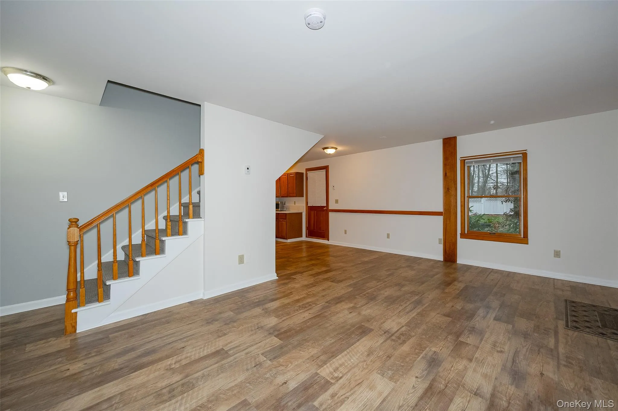 Unfurnished living room featuring stairs and dark wood-style flooring #2 Unfurnished living room featuring stairs and dark wood-style flooring #2