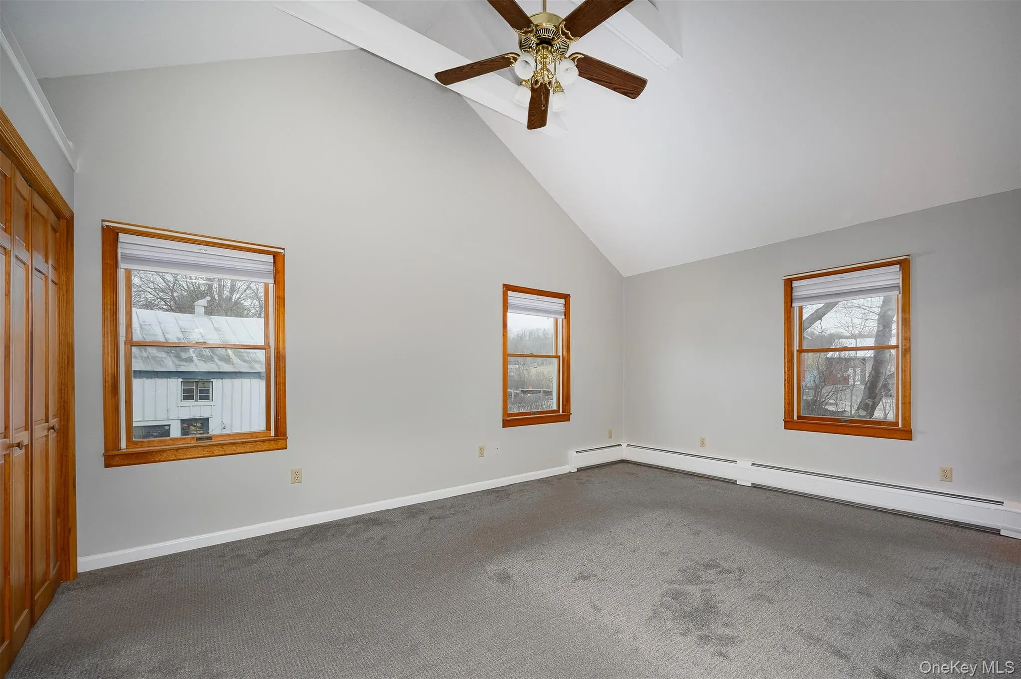 Empty room with high vaulted ceiling, ceiling fan, carpet flooring, beam ceiling, and baseboard heating #2 Empty room with high vaulted ceiling, ceiling fan, carpet flooring, beam ceiling, and baseboard heating #2