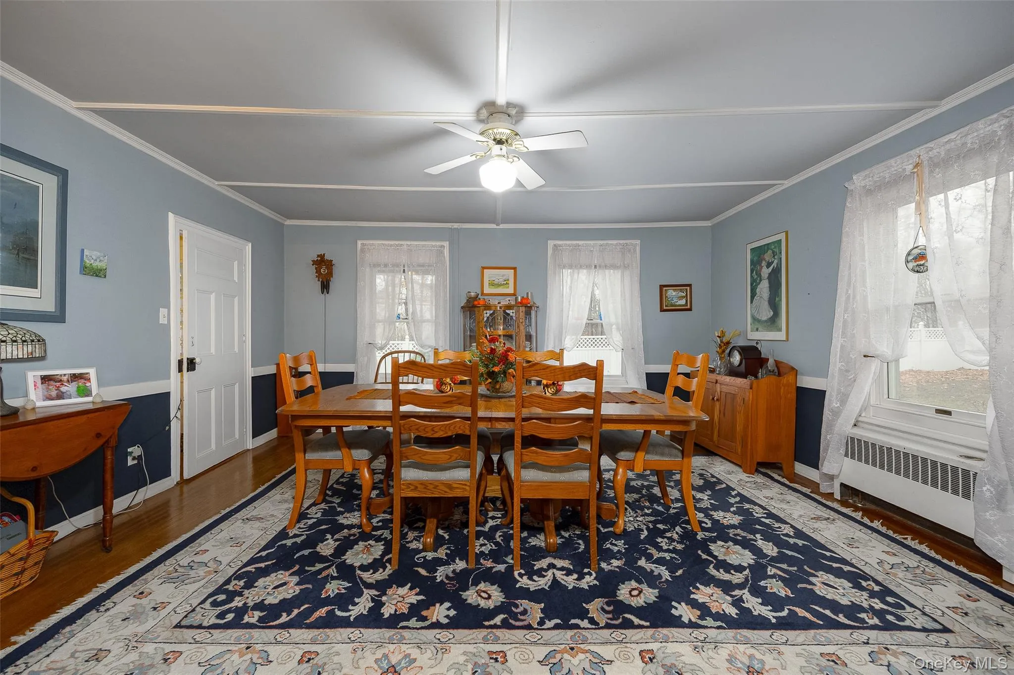 Dining area featuring wood finished floors, a ceiling fan, radiator, and ornamental molding Dining area featuring wood finished floors, a ceiling fan, radiator, and ornamental molding