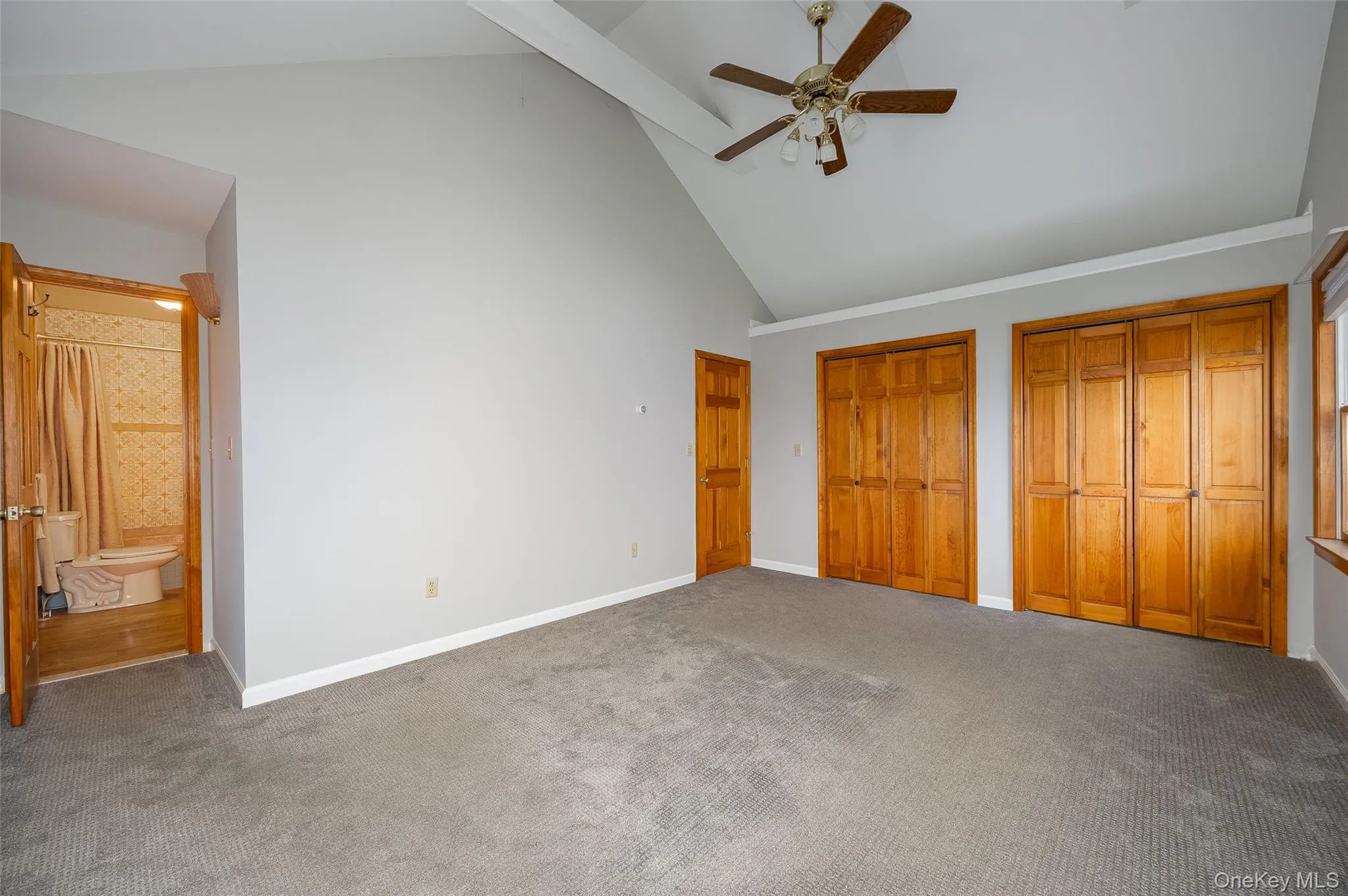 Unfurnished bedroom featuring high vaulted ceiling, multiple closets, ensuite bathroom, ceiling fan, and carpet flooring #2 Unfurnished bedroom featuring high vaulted ceiling, multiple closets, ensuite bathroom, ceiling fan, and carpet flooring #2