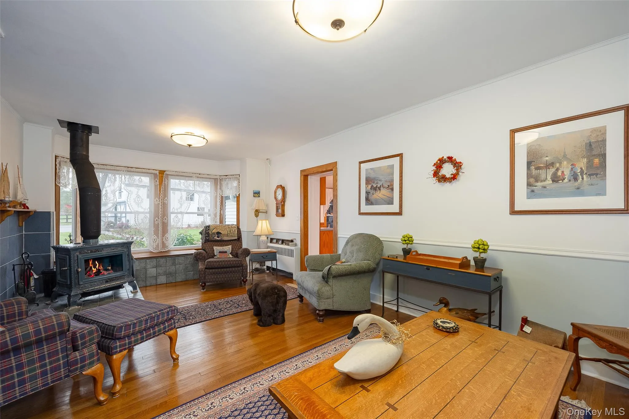 Living area with a wood stove, hardwood / wood-style floors, and radiator Living area with a wood stove, hardwood / wood-style floors, and radiator