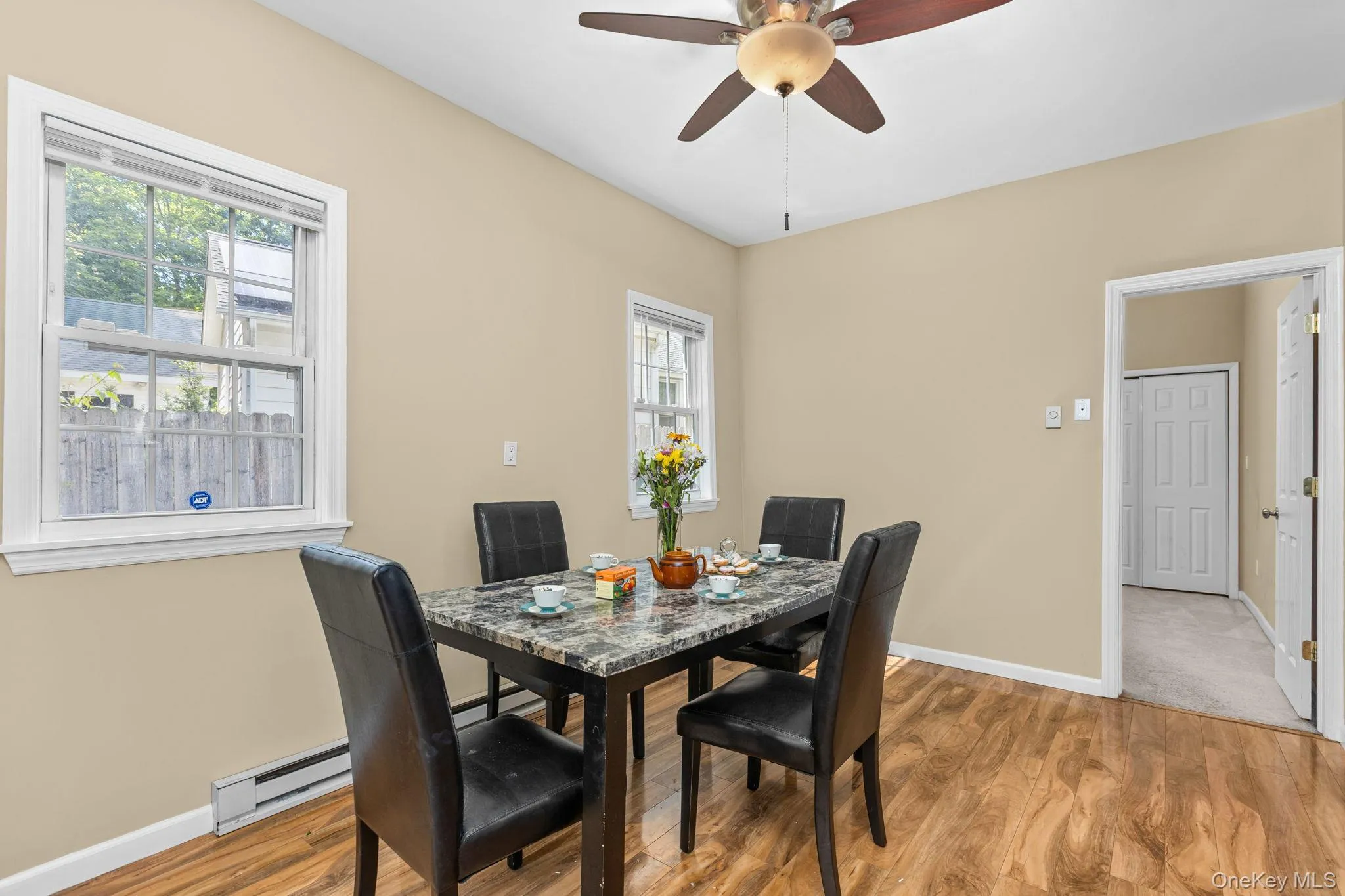 Dining area featuring wood-finish flooring, neutral wall tones, and a ceiling fan Dining area featuring wood-finish flooring, neutral wall tones, and a ceiling fan
