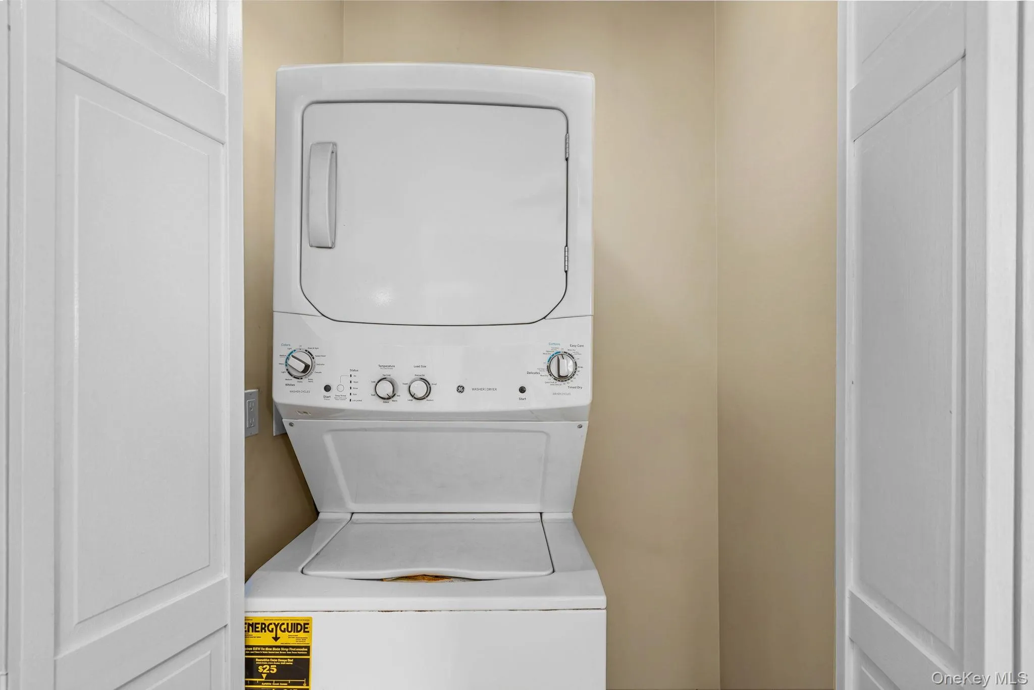 White stacked washer and dryer unit, featuring a top-load washer and front-load dryer White stacked washer and dryer unit, featuring a top-load washer and front-load dryer