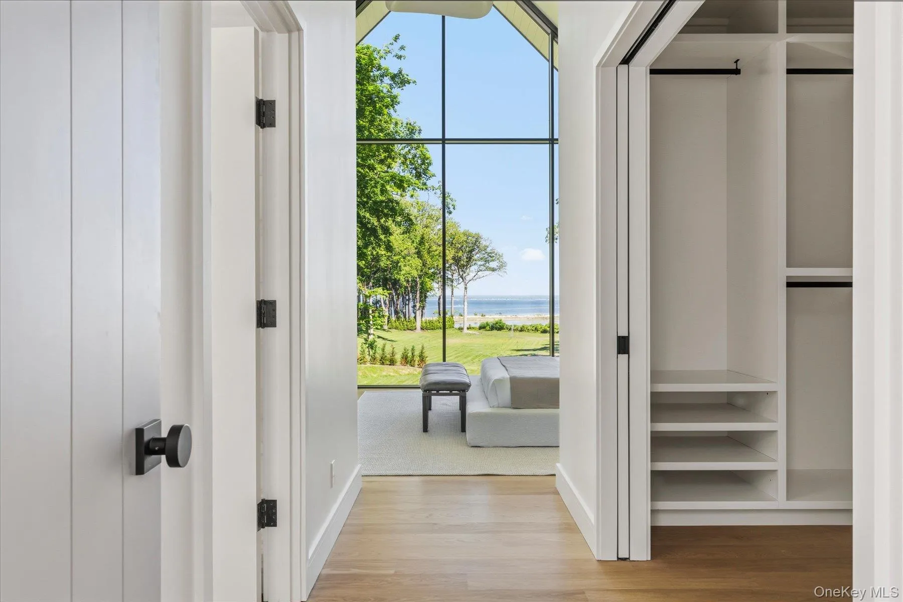 Second floor primary bedroom and walk in closet with water views Second floor primary bedroom and walk in closet with water views