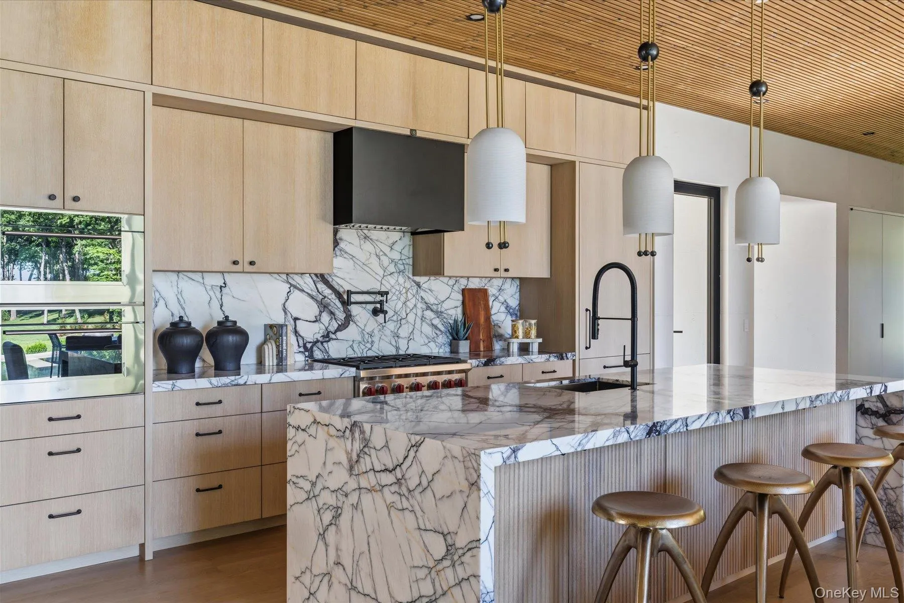 Chef’s kitchen with oversized lilac marble island and custom cabinetry Chef’s kitchen with oversized lilac marble island and custom cabinetry