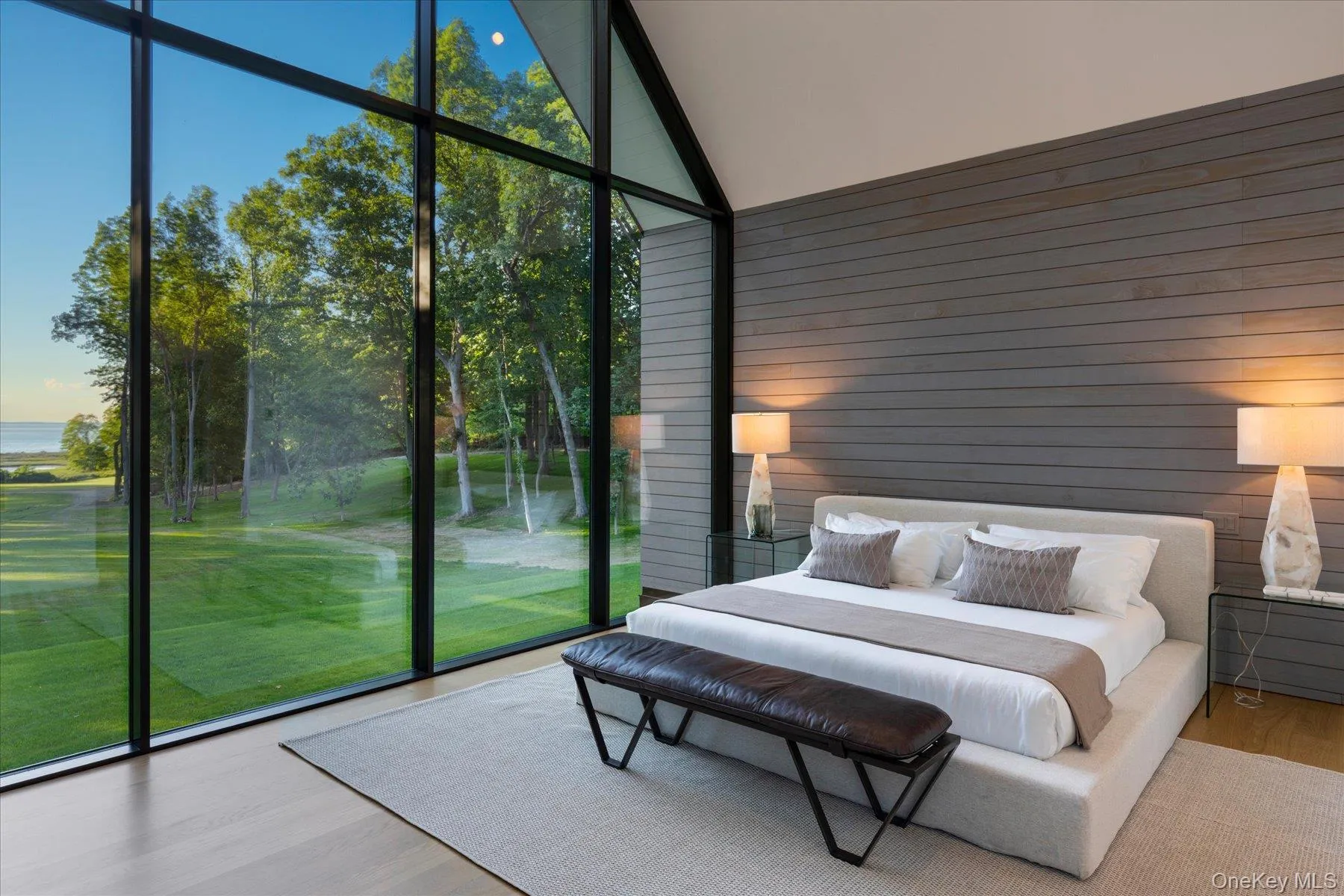 Second floor primary bedroom with stunning floor to ceiling windows and water views with en suite bath and expansive walk in closet Second floor primary bedroom with stunning floor to ceiling windows and water views with en suite bath and expansive walk in closet