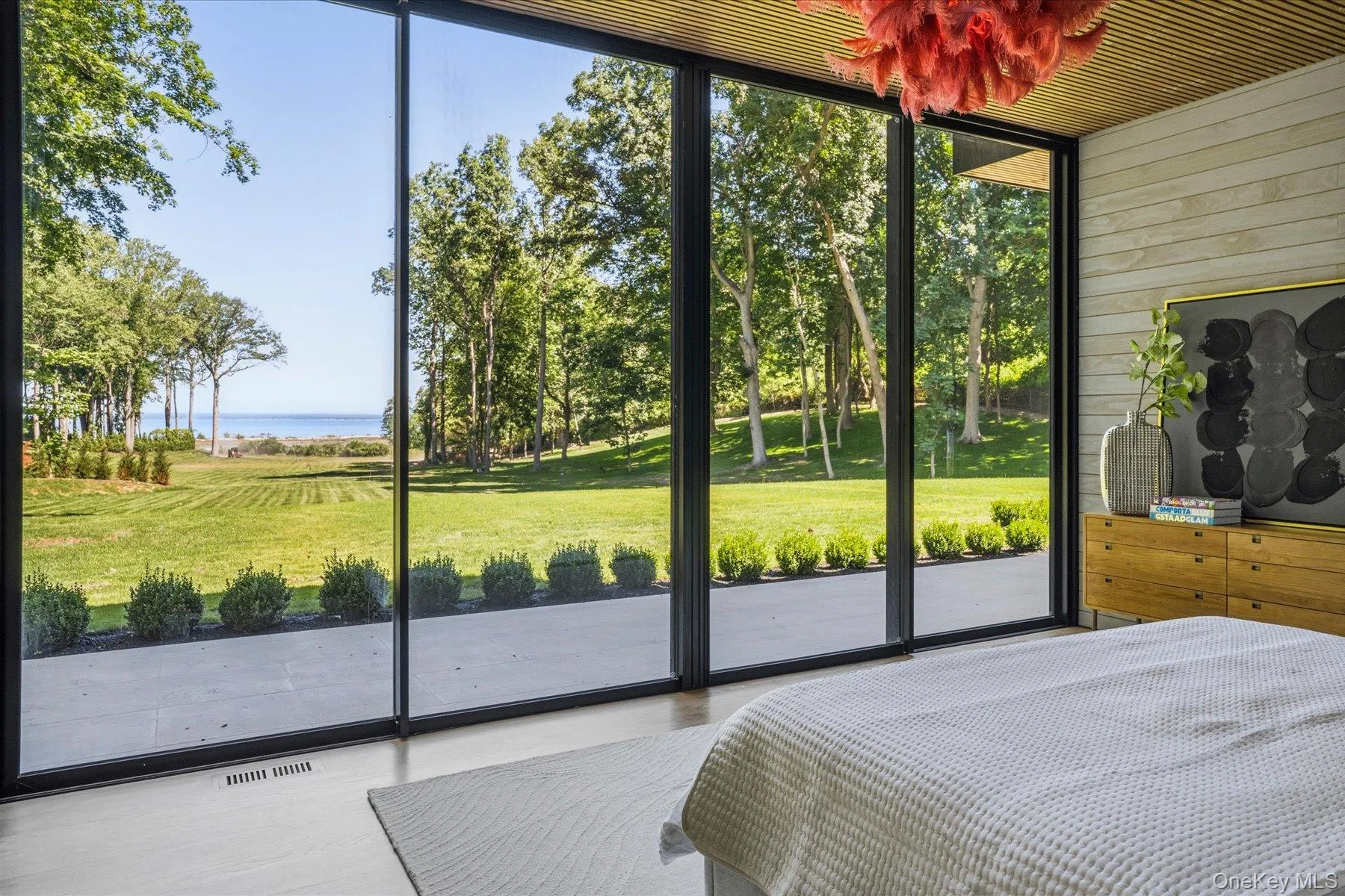 First floor primary bedroom with floor to ceiling windows, access to outdoor terrace, large walk-in closet and en suite bath. First floor primary bedroom with floor to ceiling windows, access to outdoor terrace, large walk-in closet and en suite bath.