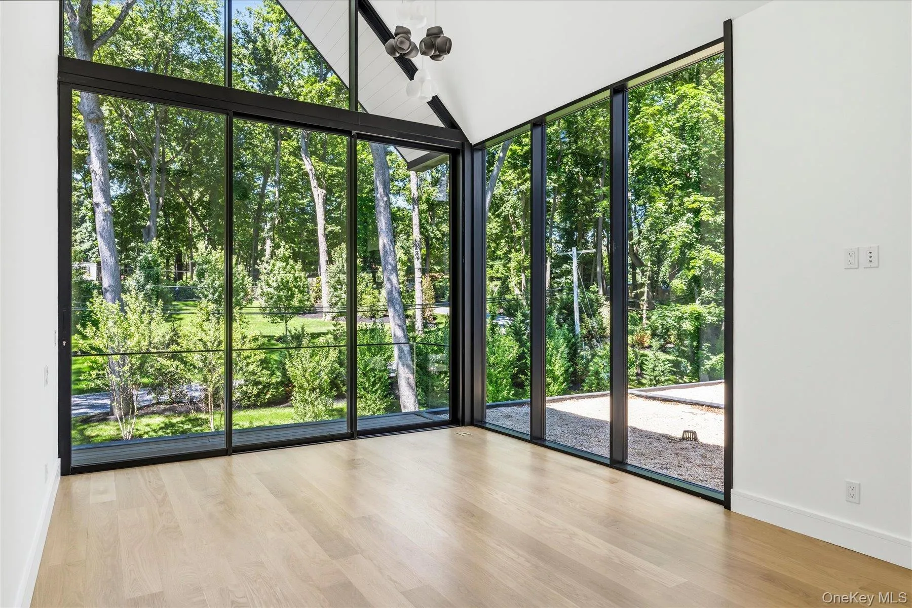Second floor bedroom with floor to ceiling windows and outdoor access to balcony with water views Second floor bedroom with floor to ceiling windows and outdoor access to balcony with water views