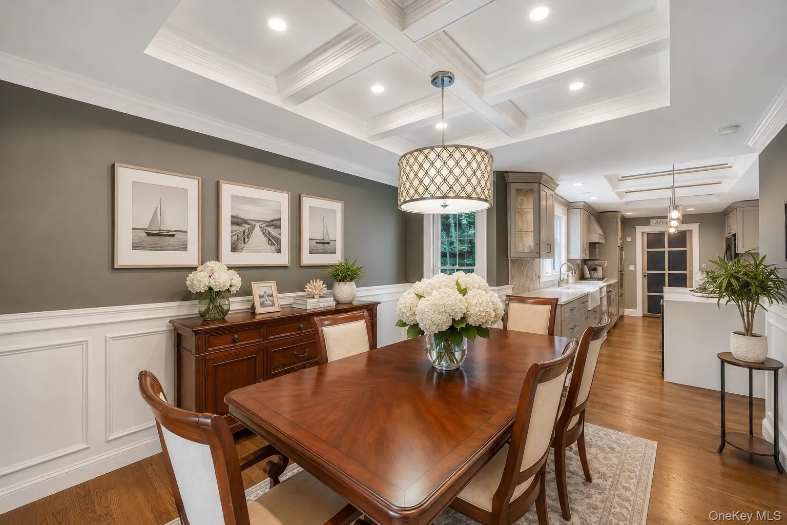 Dining area featuring coffered ceilings with recessed lighting, wood-finish flooring, and wainscoting Dining area featuring coffered ceilings with recessed lighting, wood-finish flooring, and wainscoting