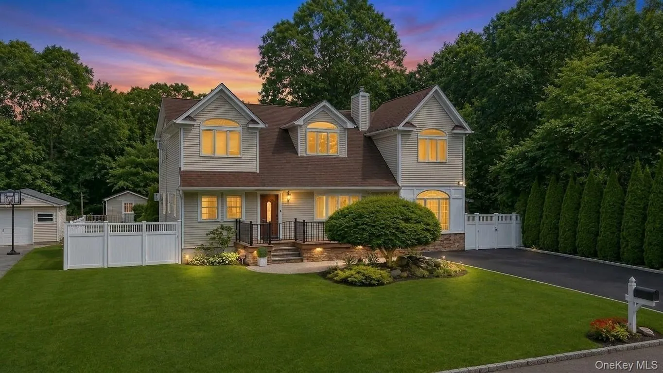 Light-colored siding exterior with a brown shingle roof, stone veneer accents, and dormer windows Light-colored siding exterior with a brown shingle roof, stone veneer accents, and dormer windows