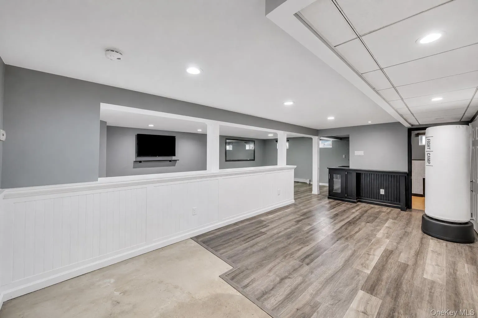 Spacious lower level featuring wood-finish flooring, recessed lighting, and a built-in wet bar with a beverage refrigerator Spacious lower level featuring wood-finish flooring, recessed lighting, and a built-in wet bar with a beverage refrigerator