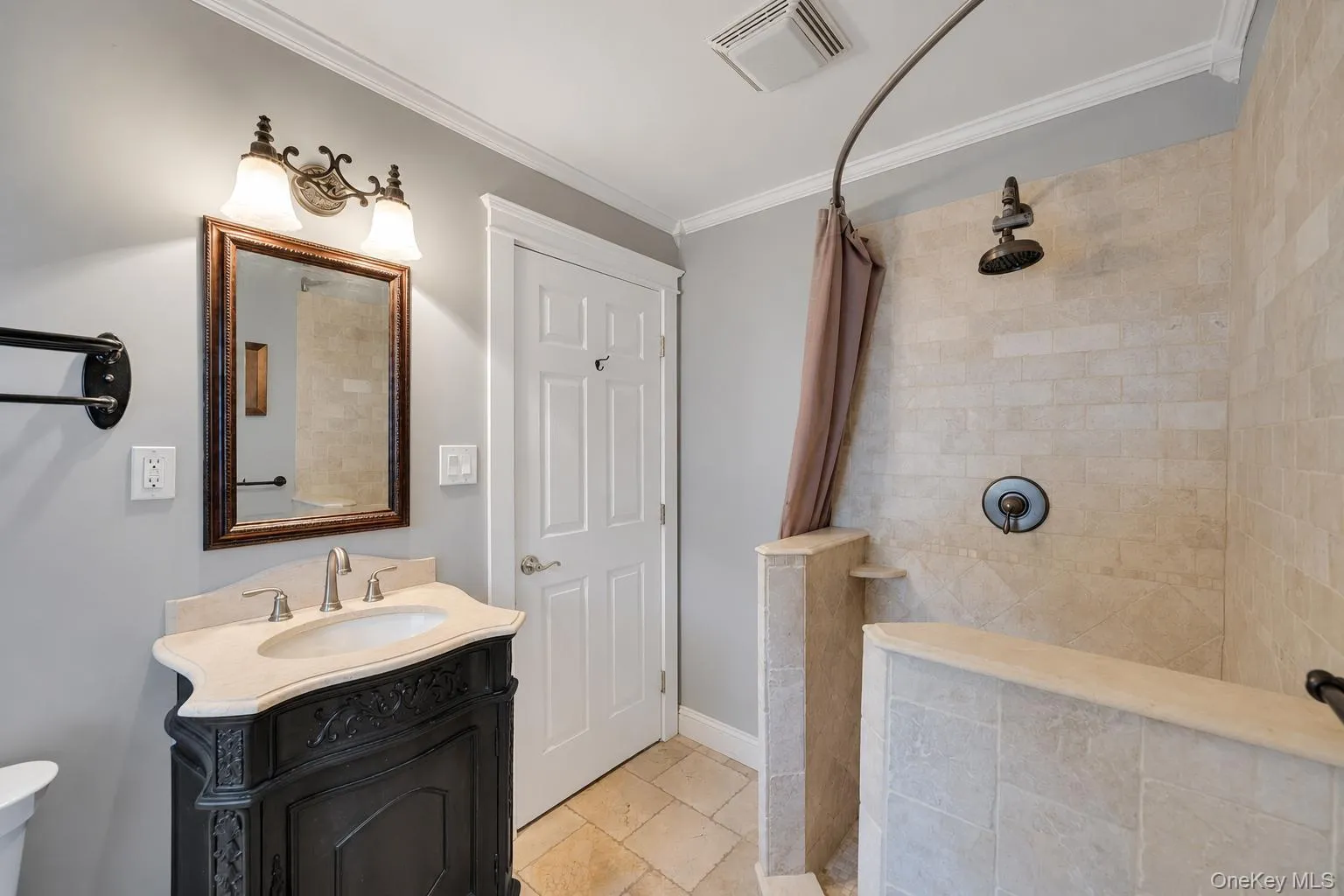 Walk-in shower with tiled walls and floor, featuring a dark bronze rainfall showerhead and control Walk-in shower with tiled walls and floor, featuring a dark bronze rainfall showerhead and control