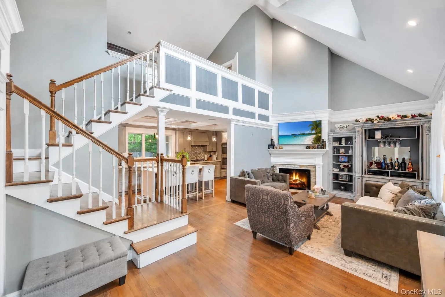 Open-concept living area featuring a vaulted ceiling and hardwood flooring Open-concept living area featuring a vaulted ceiling and hardwood flooring