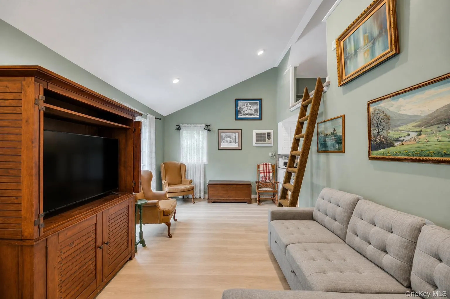 Vaulted ceilings defining a spacious living area with light wood-finish flooring Vaulted ceilings defining a spacious living area with light wood-finish flooring