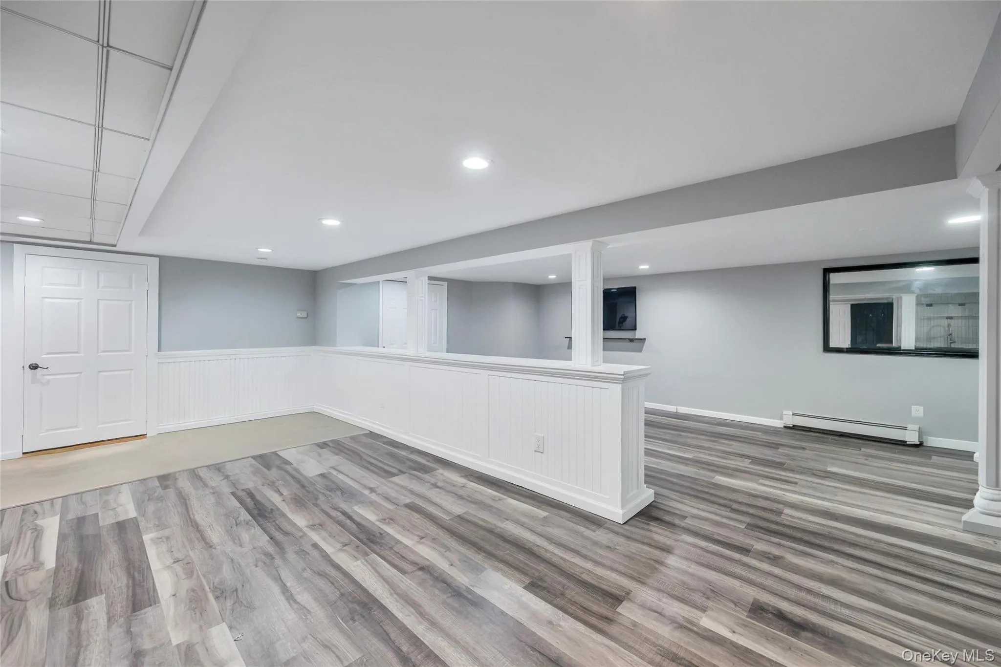 Spacious lower level featuring wood-finish flooring, recessed lighting, and a built-in wet bar with a beverage refrigerator Spacious lower level featuring wood-finish flooring, recessed lighting, and a built-in wet bar with a beverage refrigerator