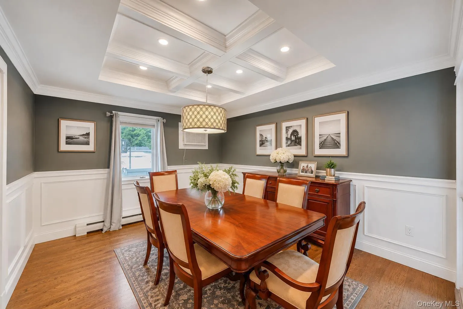 Coffered ceiling with recessed lighting and a decorative chandelier Coffered ceiling with recessed lighting and a decorative chandelier