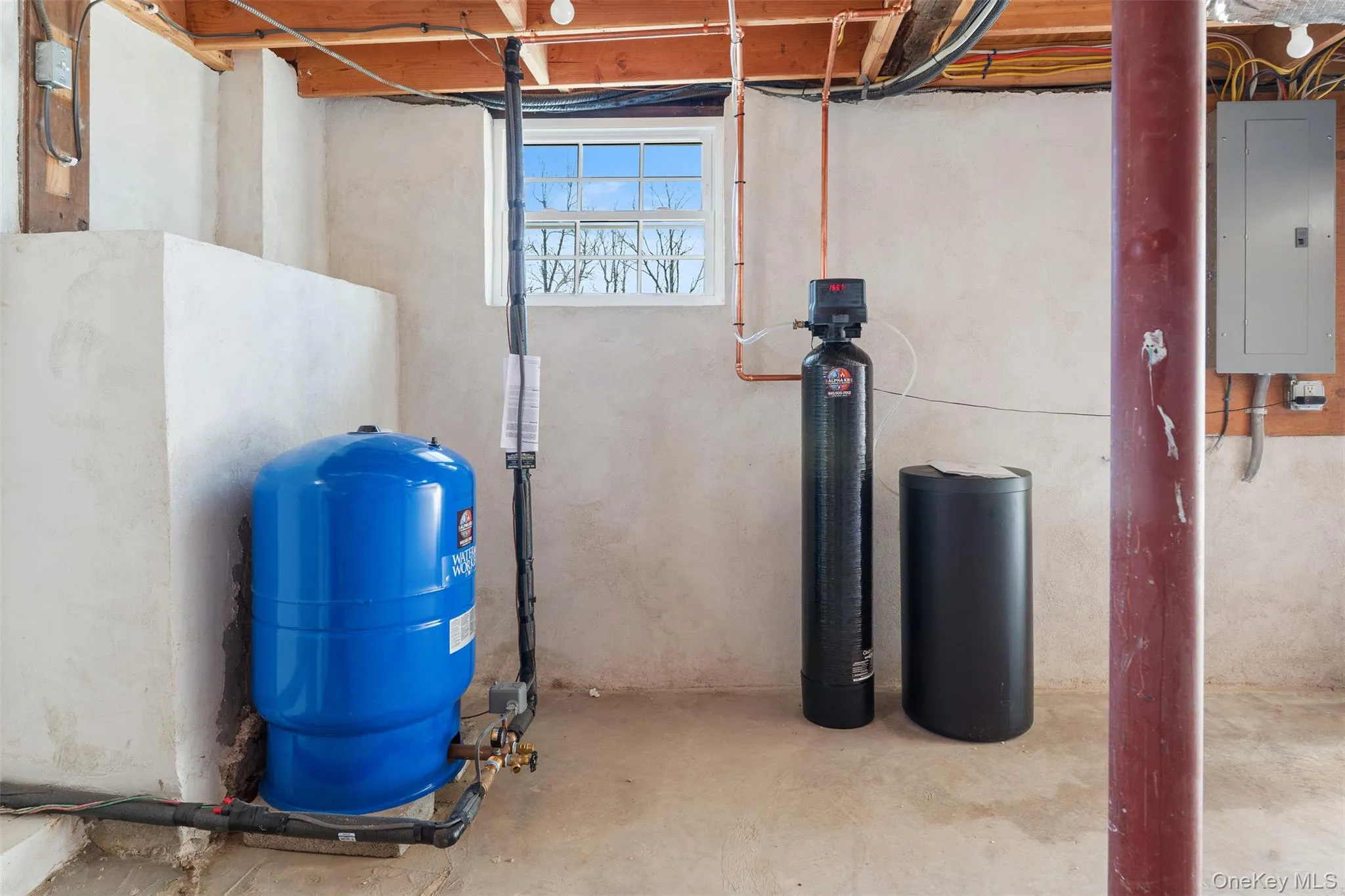 Below grade area featuring electric panel, a water pressure tank, and a water softener Below grade area featuring electric panel, a water pressure tank, and a water softener