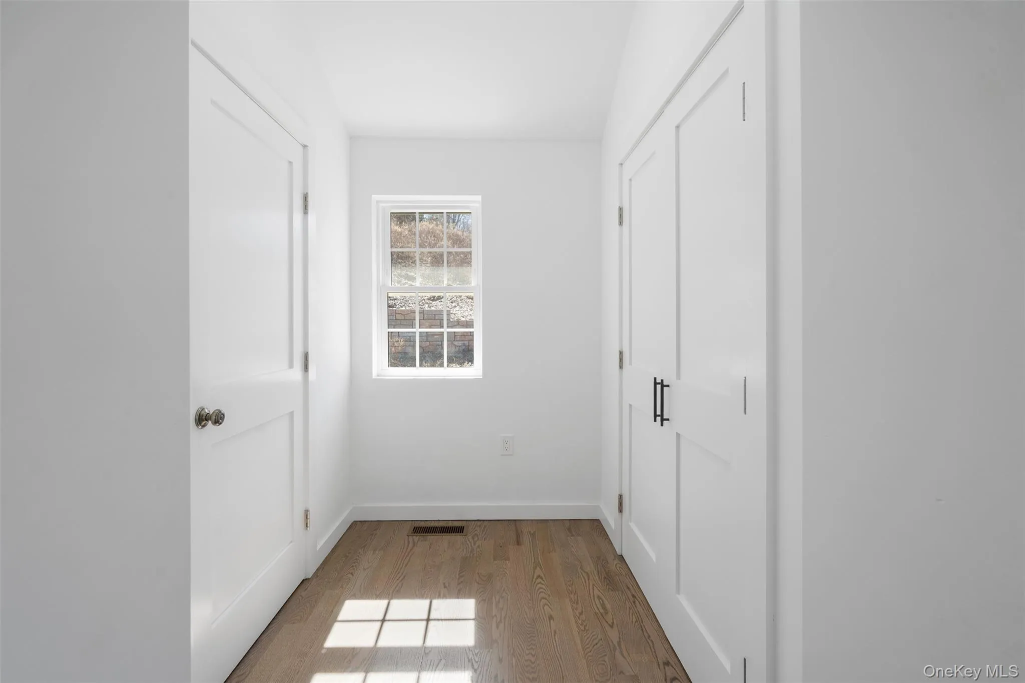 Hallway with wood finished floors and baseboards Hallway with wood finished floors and baseboards
