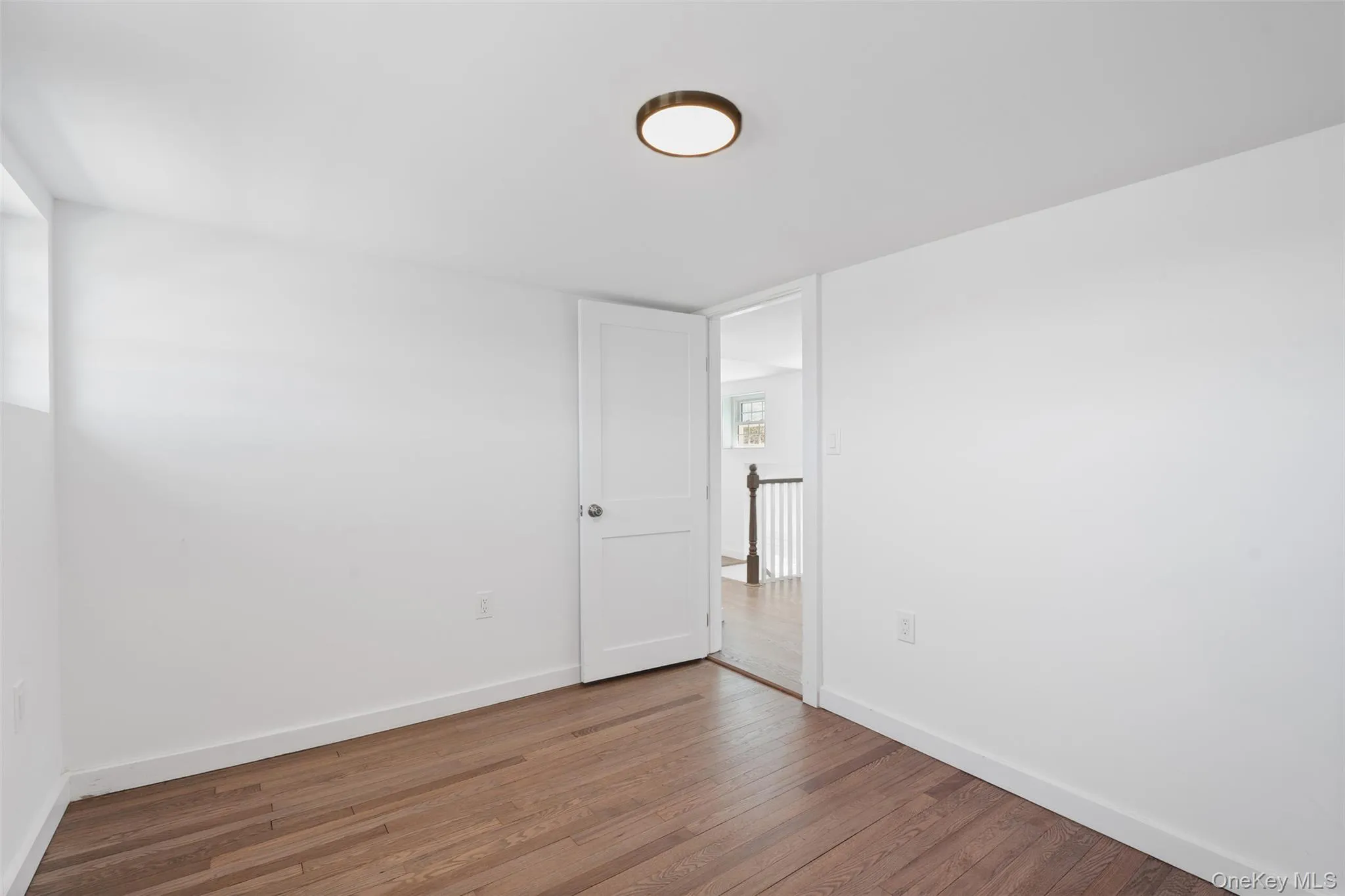 Spare room featuring wood finished floors and baseboards Spare room featuring wood finished floors and baseboards