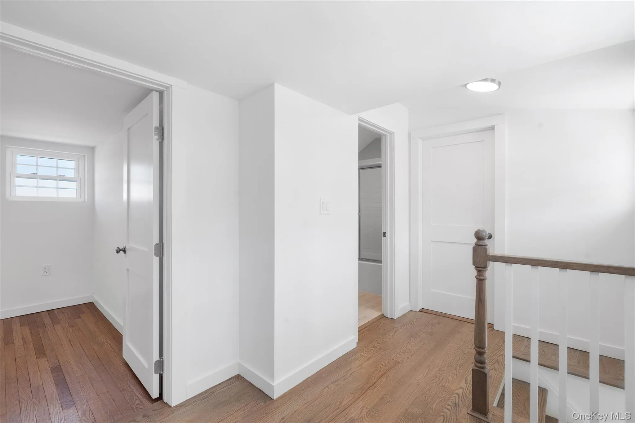 Corridor with light wood-type flooring and an upstairs landing Corridor with light wood-type flooring and an upstairs landing