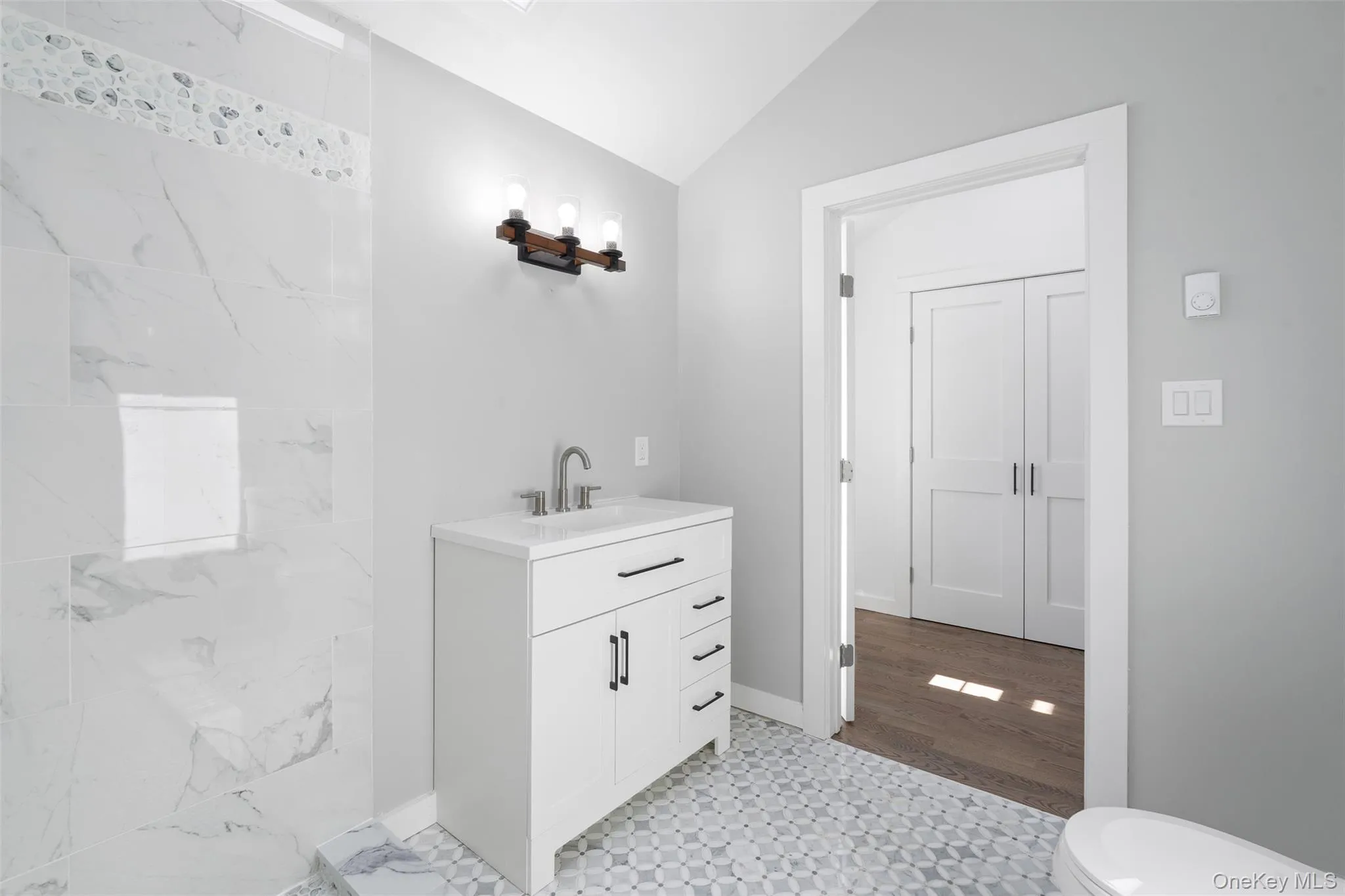 Bathroom featuring vanity and lofted ceiling Bathroom featuring vanity and lofted ceiling