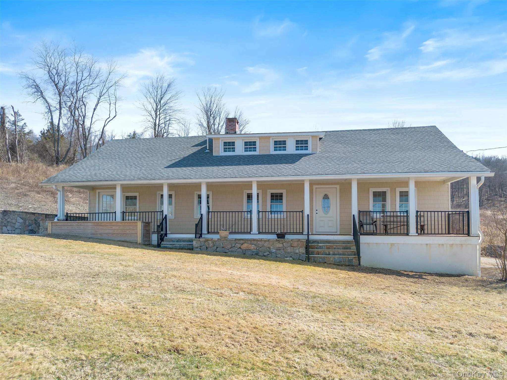 Country-style home featuring covered porch, roof with shingles, and a chimney Country-style home featuring covered porch, roof with shingles, and a chimney