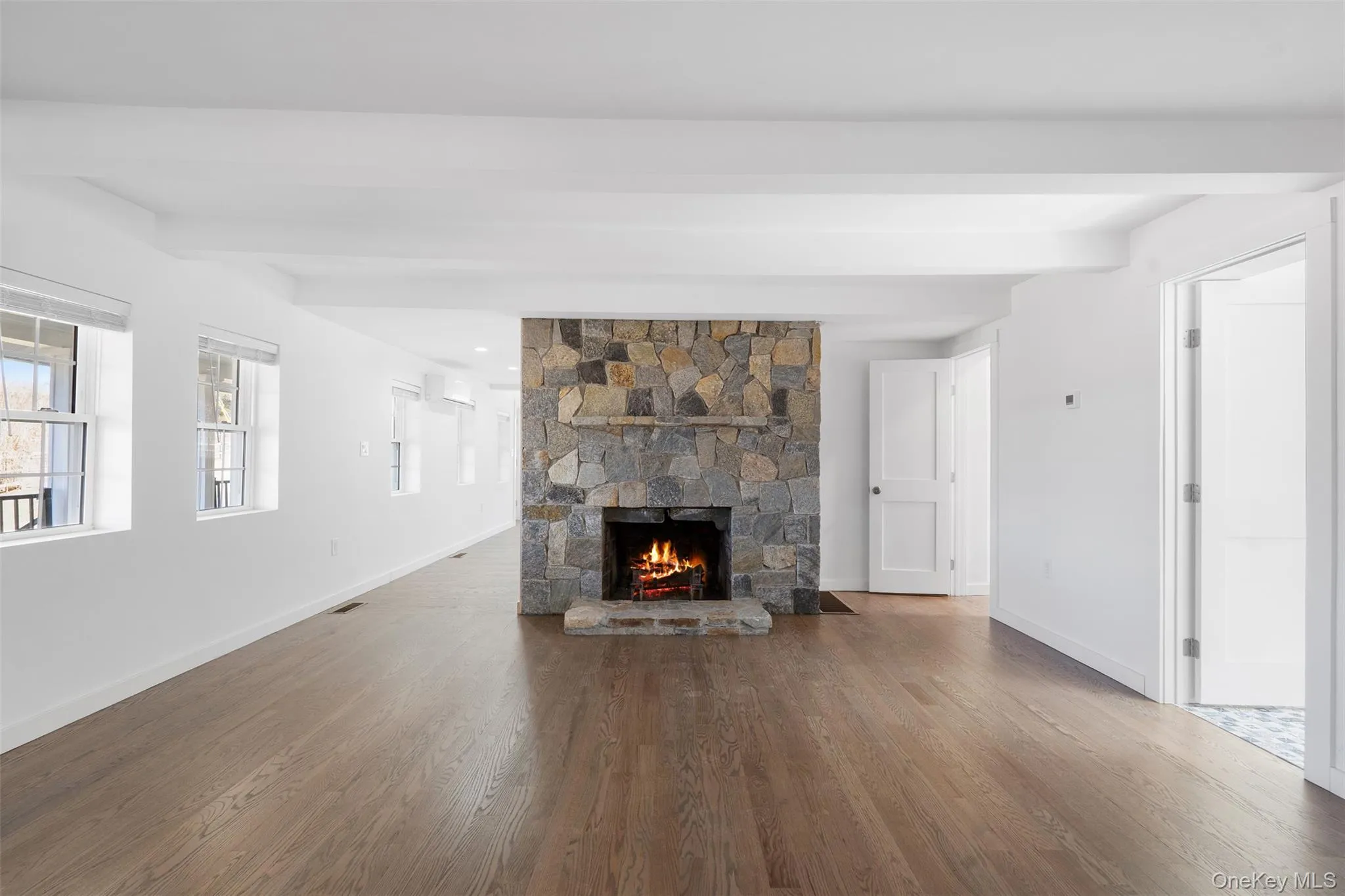 Unfurnished living room with healthy amount of natural light, wood finished floors, and a fireplace Unfurnished living room with healthy amount of natural light, wood finished floors, and a fireplace
