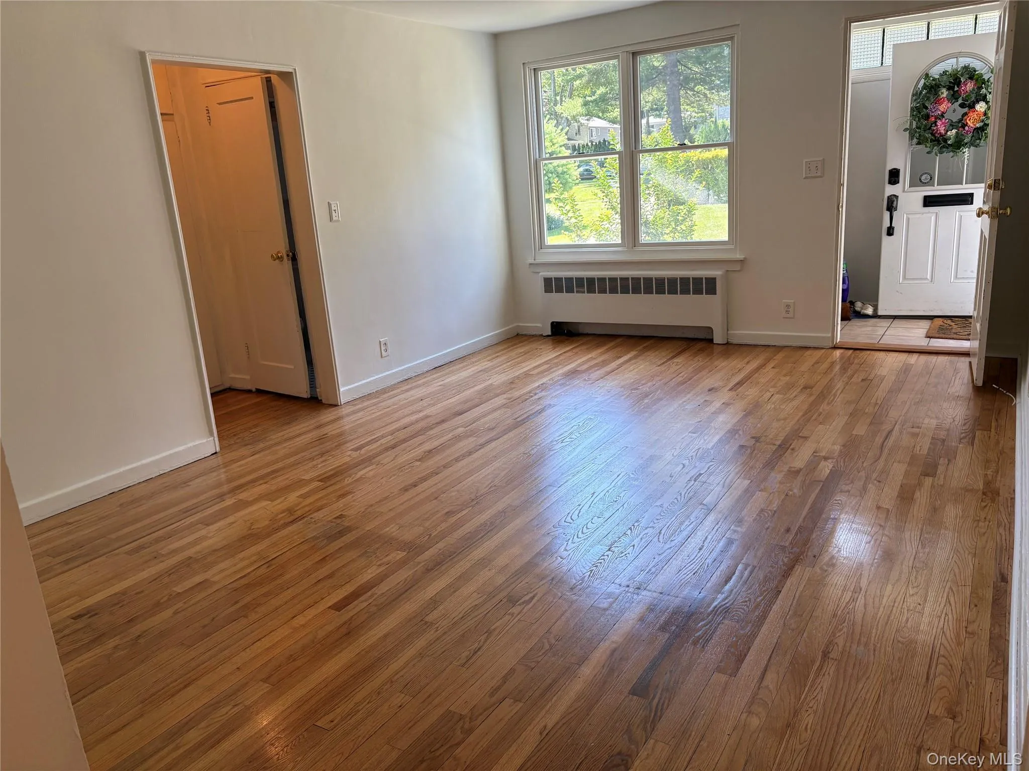 Hardwood flooring throughout a room with white painted walls and white baseboards. View from Dining area. Hardwood flooring throughout a room with white painted walls and white baseboards. View from Dining area.