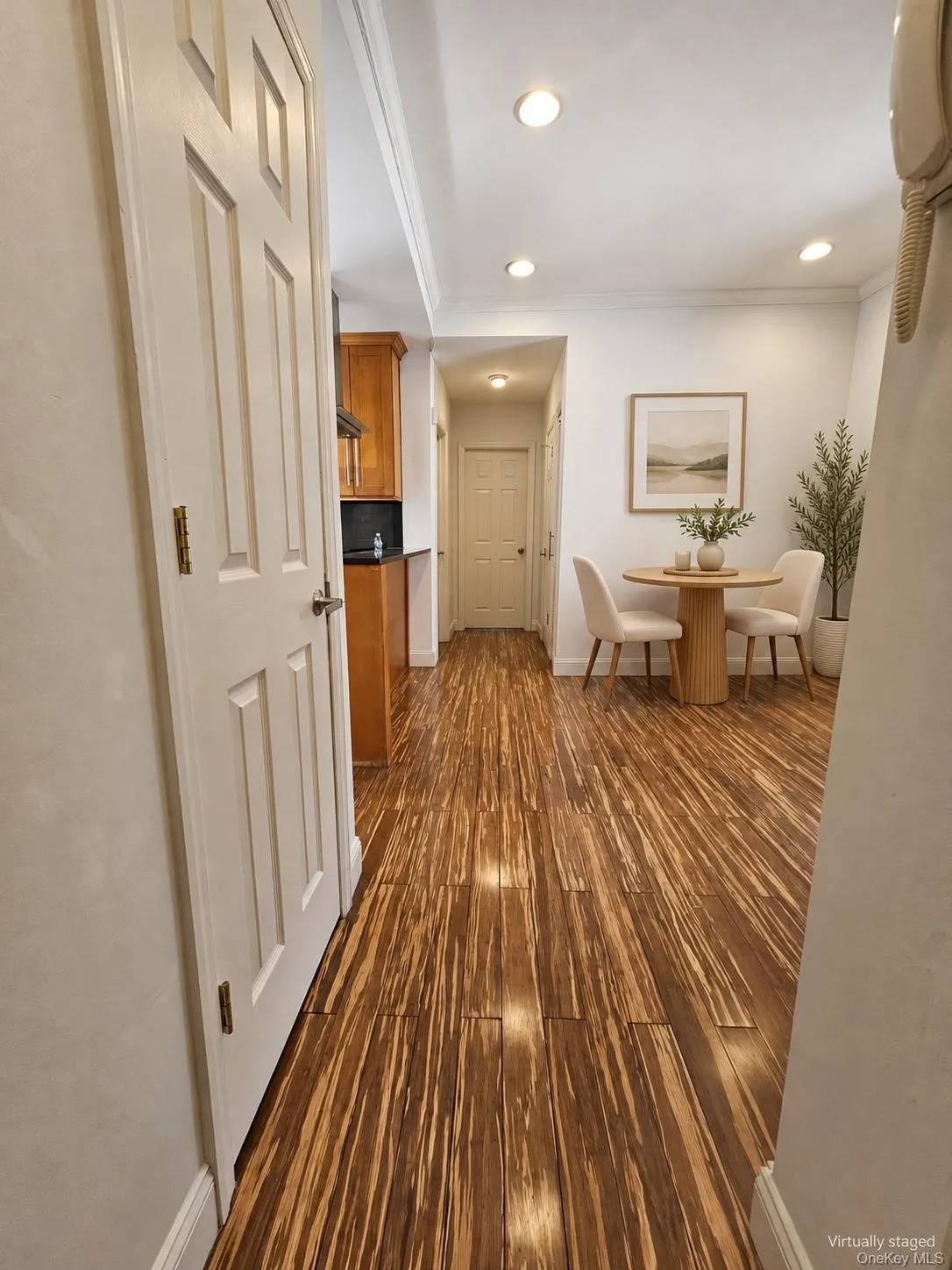 Wood-finish flooring throughout, recessed lighting, and a paneled interior door Wood-finish flooring throughout, recessed lighting, and a paneled interior door