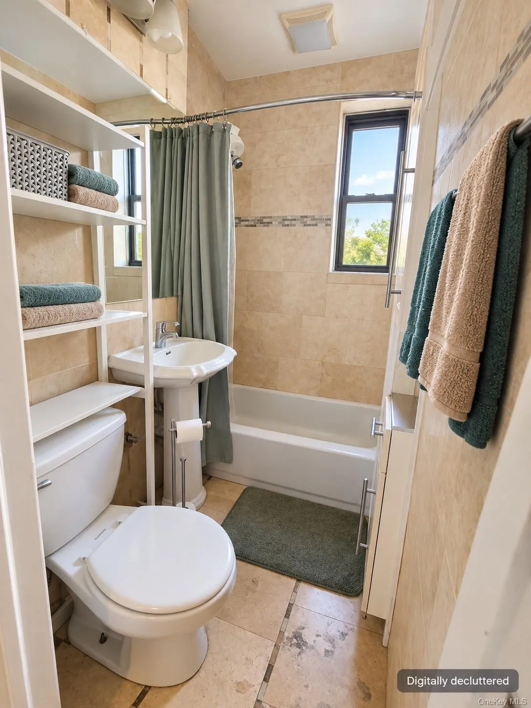Bathroom featuring a pedestal sink, white bathtub, and tile flooring Bathroom featuring a pedestal sink, white bathtub, and tile flooring