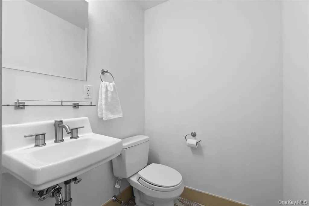 Bathroom with toilet, a sink, and baseboards Bathroom with toilet, a sink, and baseboards