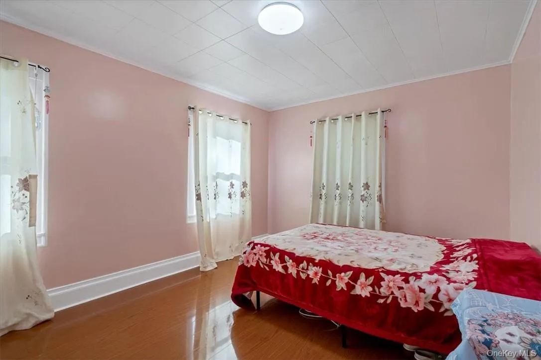 Bedroom with hardwood / wood-style flooring and ornamental molding Bedroom with hardwood / wood-style flooring and ornamental molding