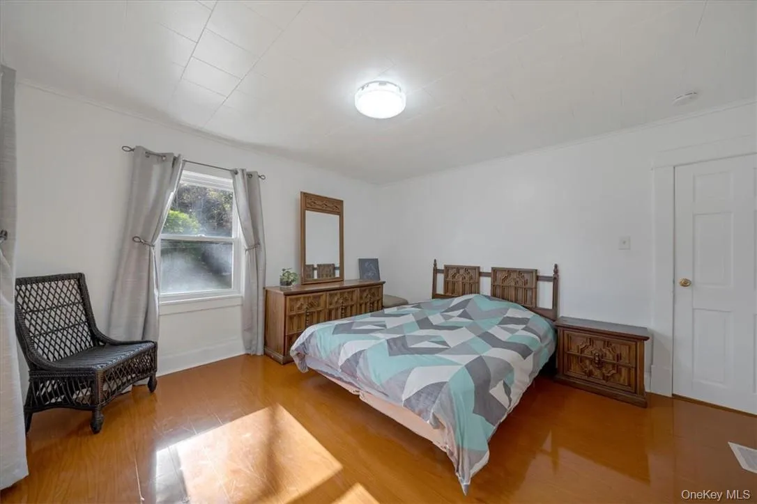 Bedroom with ornamental molding and hardwood / wood-style floors Bedroom with ornamental molding and hardwood / wood-style floors