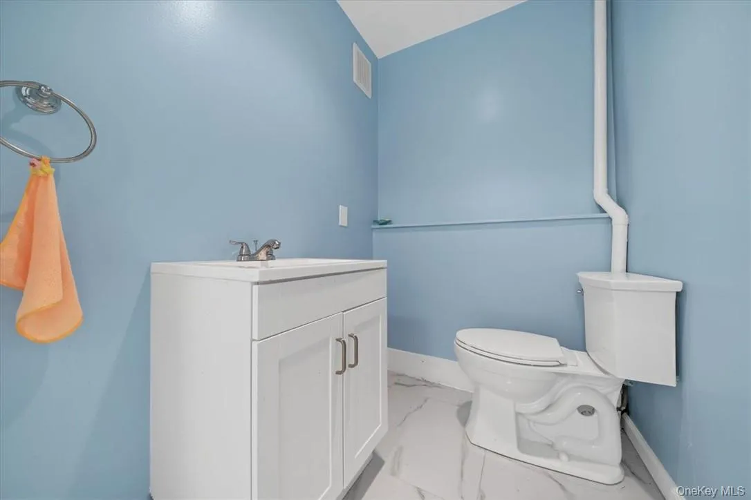Bathroom with vaulted ceiling, vanity, and toilet Bathroom with vaulted ceiling, vanity, and toilet