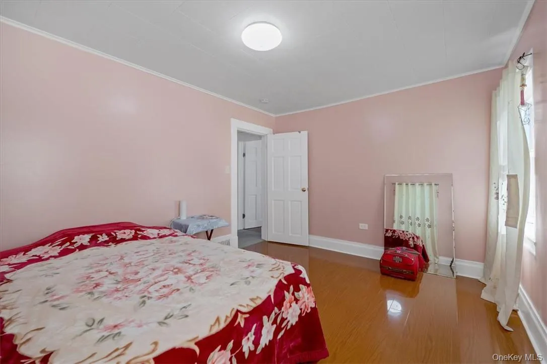 Bedroom with ornamental molding and wood-type flooring Bedroom with ornamental molding and wood-type flooring