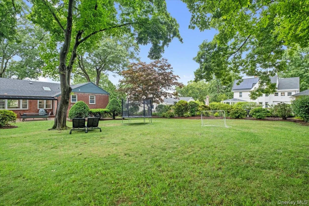 Expansive green lawn with mature trees and established perimeter landscaping Expansive green lawn with mature trees and established perimeter landscaping