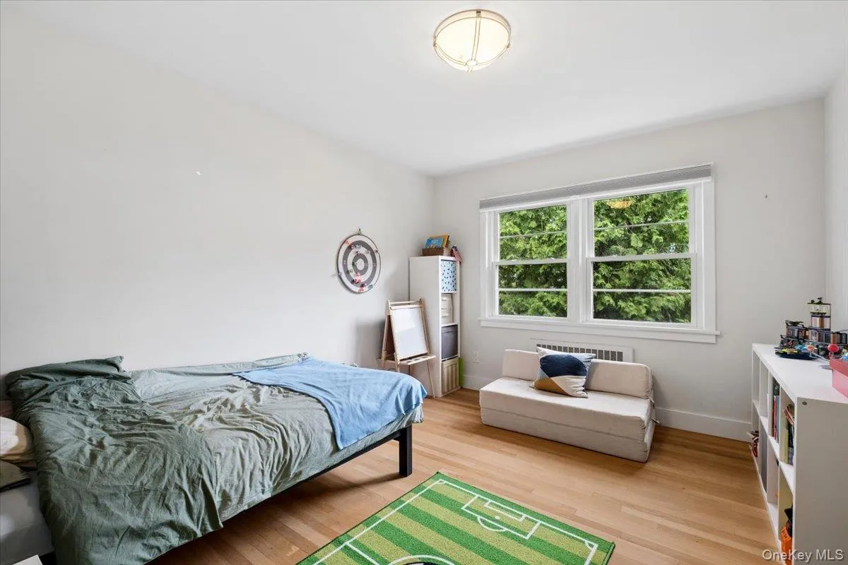 Room featuring hard wood flooring and a large window with white trim Room featuring hard wood flooring and a large window with white trim