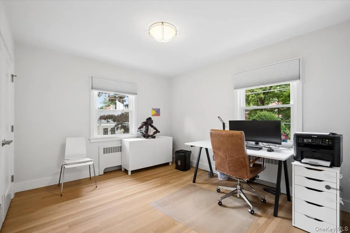 Bright bedroom featuring light wood-finish flooring and white walls Bright bedroom featuring light wood-finish flooring and white walls