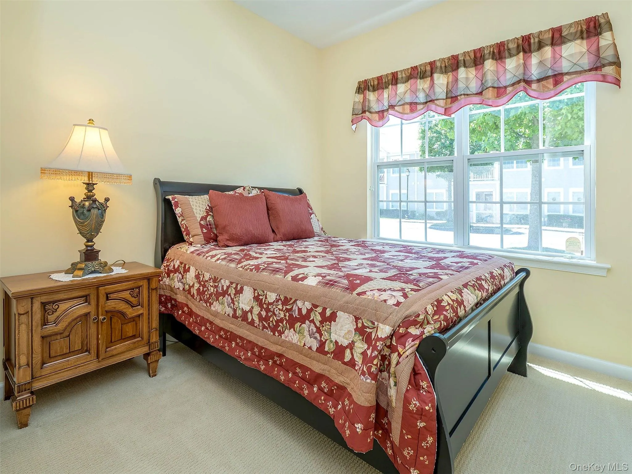 Bedroom featuring light yellow walls and neutral tone carpeting Bedroom featuring light yellow walls and neutral tone carpeting