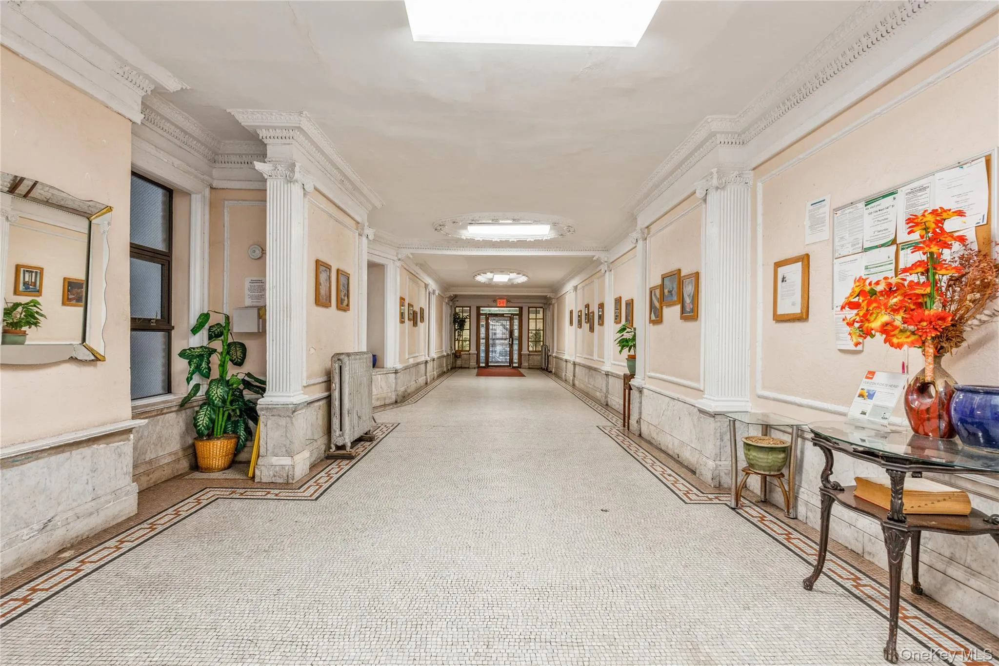 Hall featuring crown molding and decorative columns Hall featuring crown molding and decorative columns