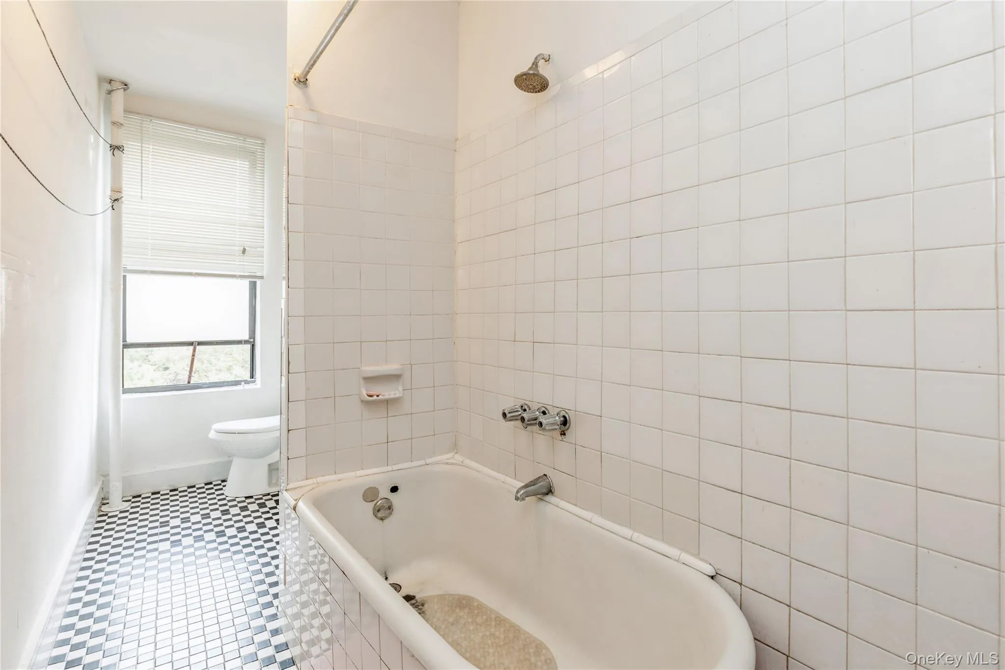 Bathroom featuring toilet and tiled shower / bath combo Bathroom featuring toilet and tiled shower / bath combo