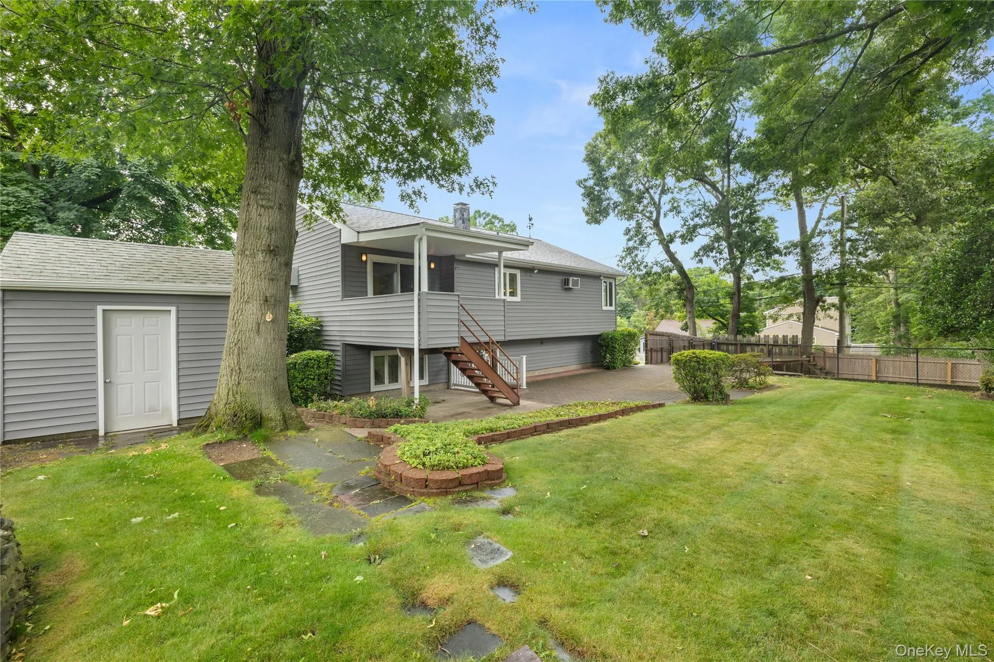 Spacious backyard featuring a manicured lawn, established trees Spacious backyard featuring a manicured lawn, established trees