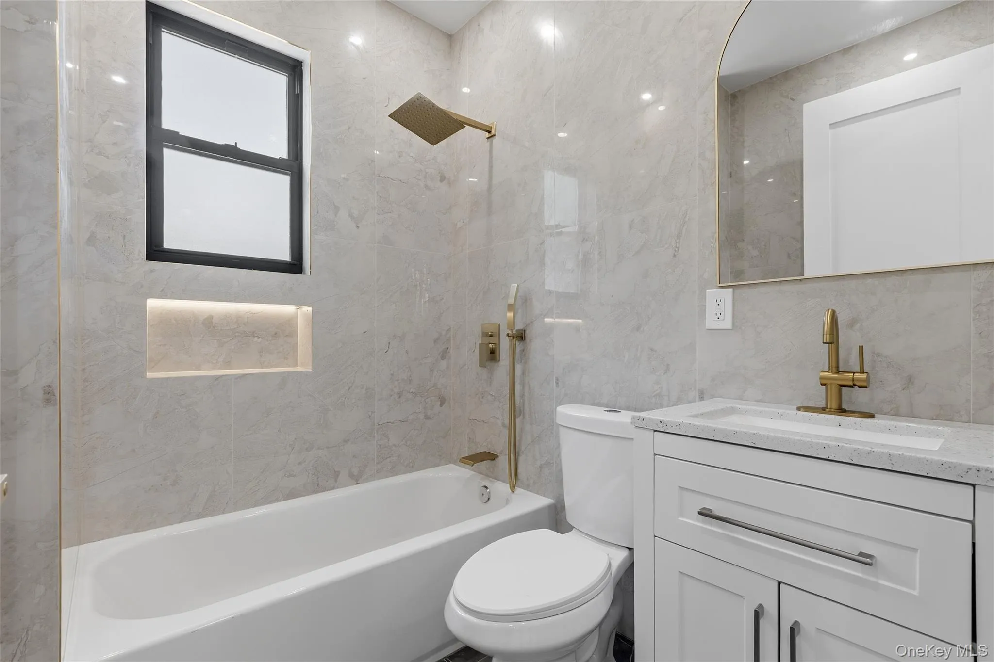 Bathroom featuring a white bathtub, a window with black trim, and a built-in shower niche with integrated lighting Bathroom featuring a white bathtub, a window with black trim, and a built-in shower niche with integrated lighting